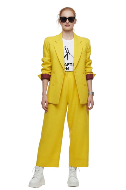 Person wearing a yellow suit with a white shirt underneath on a white background