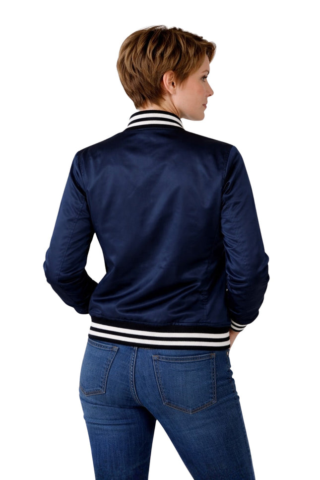 Person wearing a navy blue bomber jacket with white stripes on a white background