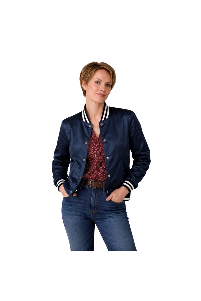 Woman wearing a navy blue jacket with white trim, red patterned shirt, and blue jeans on a white background