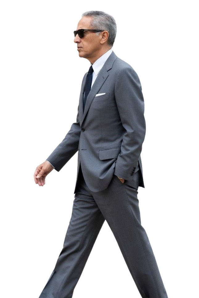 Man in a gray suit walking on a white background