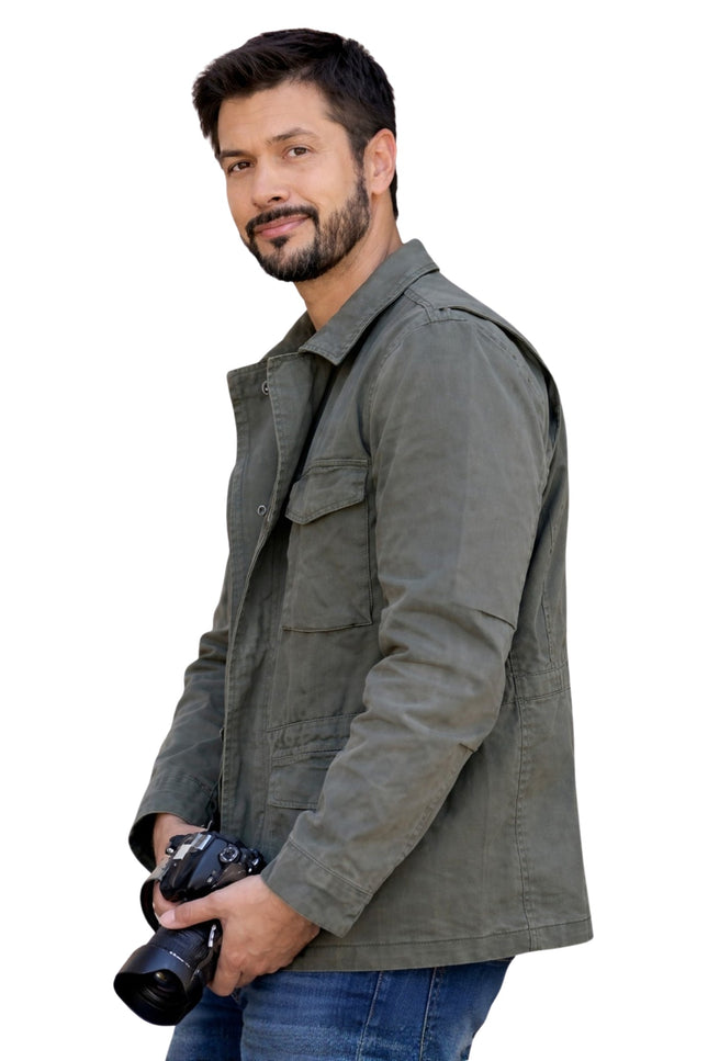 Man wearing a gray jacket holding a camera on a white background