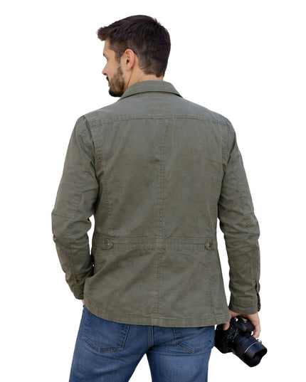 Man wearing a green jacket holding a camera on a white background