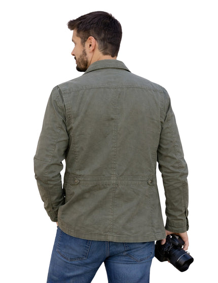 Man wearing a green jacket holding a camera on a white background