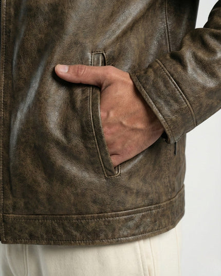 Brown leather jacket with a hand in the pocket on a white background