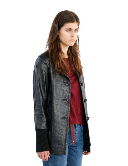 Woman wearing a black leather jacket over a red shirt on a white background