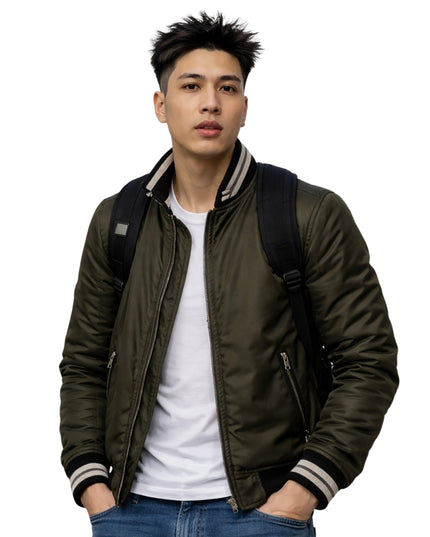 Man wearing a green bomber jacket with a white shirt and blue jeans on a white background