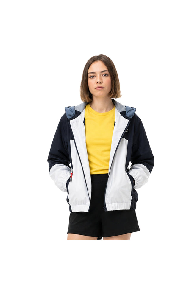 Woman wearing a black and white jacket with a yellow shirt underneath on a white background