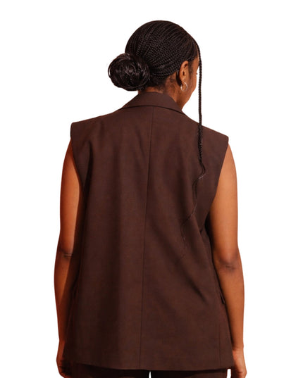 Brown vest worn by a person on a white background