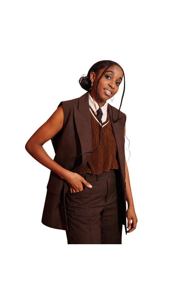 Woman wearing a brown vest and pants set on a white background