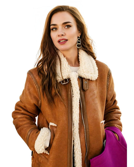 Woman wearing a brown shearling coat with white fur lining on a white background
