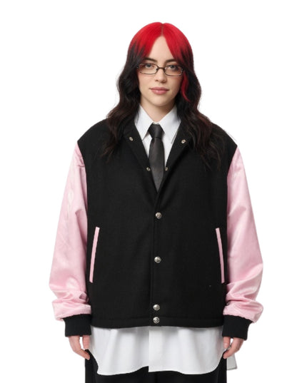 Person wearing a black and pink varsity jacket on a white background