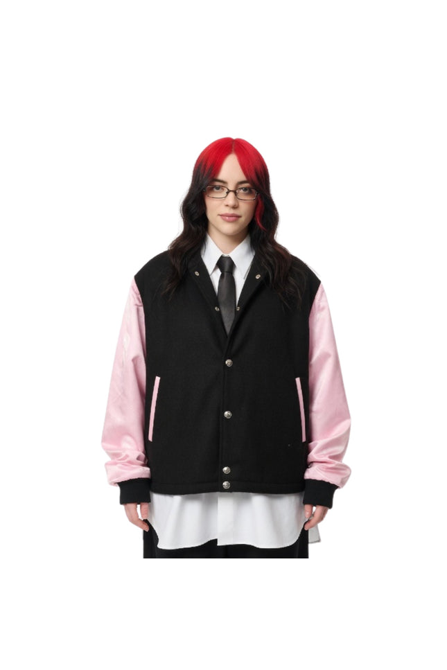 Person wearing a black and pink varsity jacket on a white background