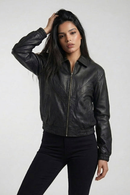 Woman wearing a black leather jacket against a plain background