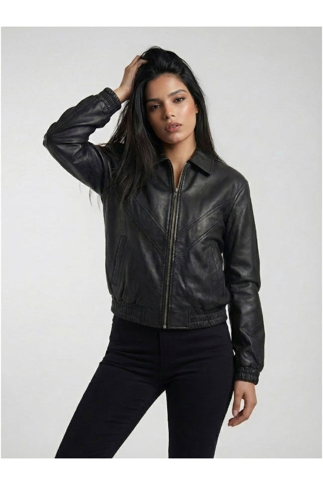 Woman wearing a black leather jacket against a plain background