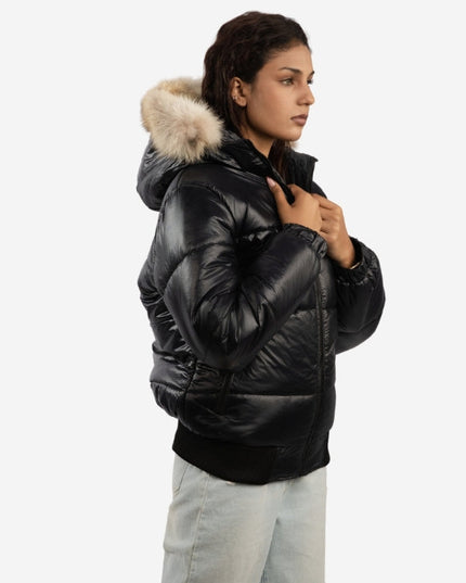 Person wearing a black puffer jacket with a fur-lined hood on a white background