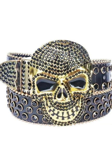 Gold skull belt buckle with black stones on a white background