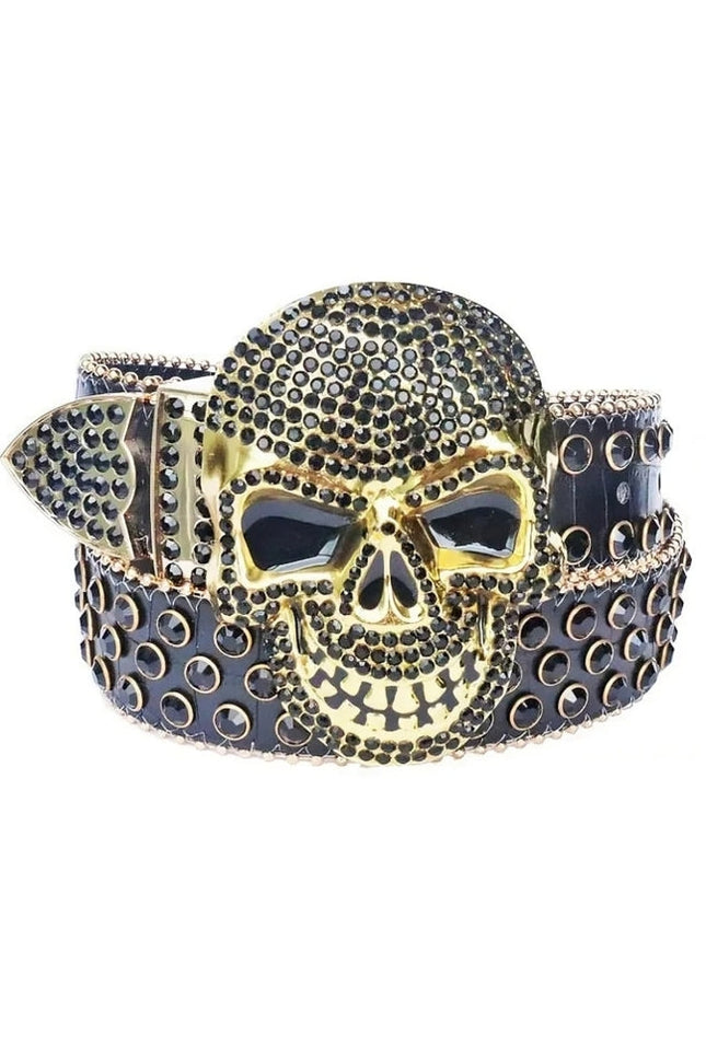 Gold skull belt buckle with black stones on a white background