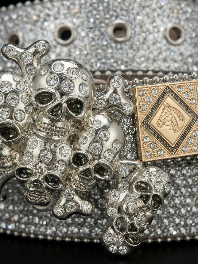 Decorative belt buckle with skull and crossbones design on a glittery background