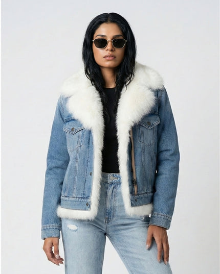 Person wearing a denim jacket with white fur trim on a light gray background