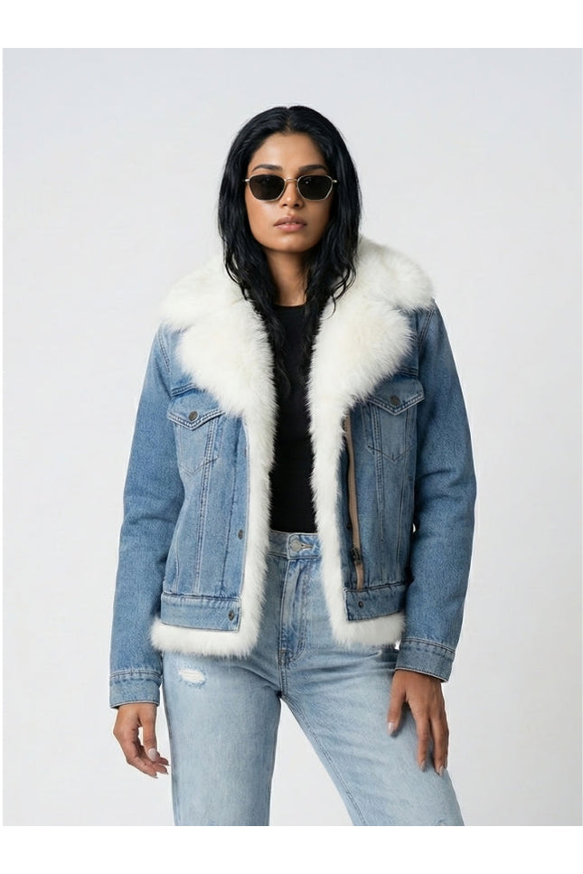 Person wearing a denim jacket with white fur trim on a light gray background
