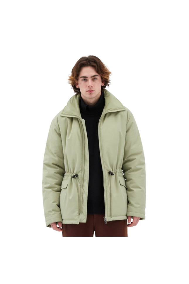 Person wearing a light green jacket on a white background