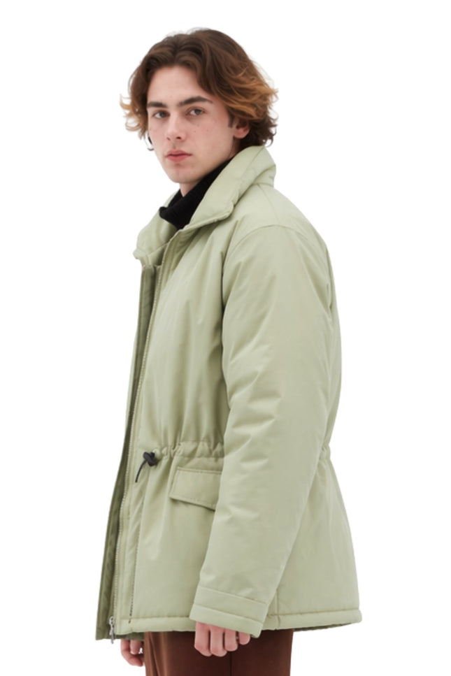 Person wearing a light green coat on a white background