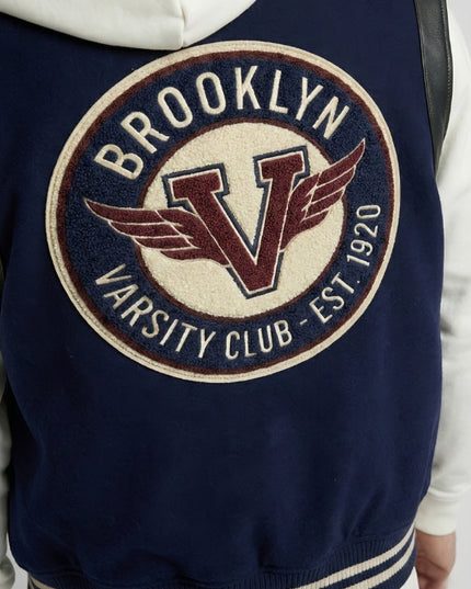 Navy blue jacket with 'Brooklyn Varsity Club' logo on a white background