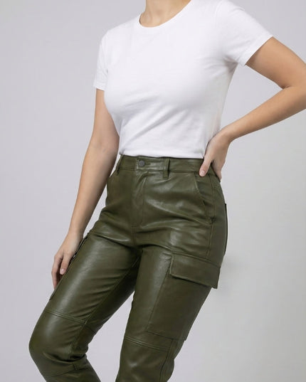 Person wearing green leather cargo pants and a white t-shirt on a plain background