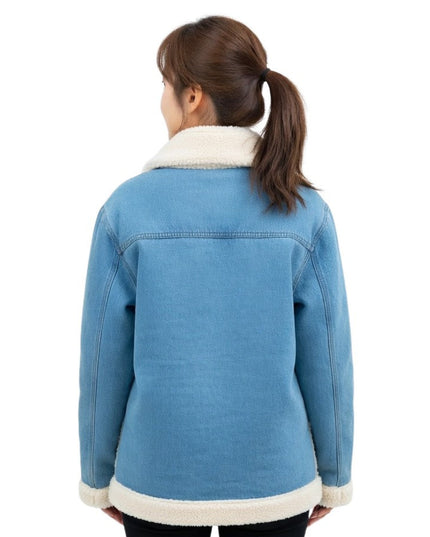 Person wearing a blue denim jacket with white fur trim on a white background