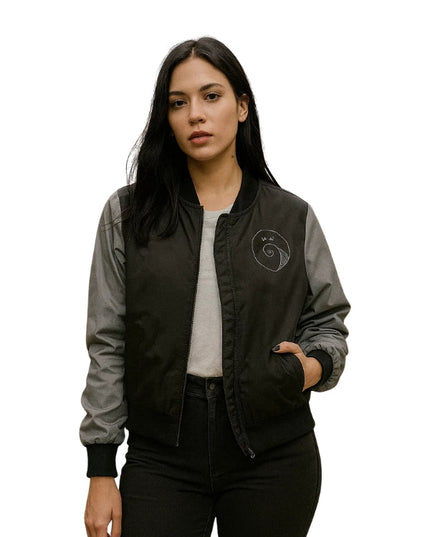 Woman wearing a black and gray bomber jacket with a logo on a white background