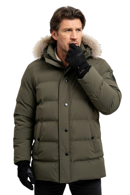 Man wearing a green winter coat with a fur-lined hood on a white background