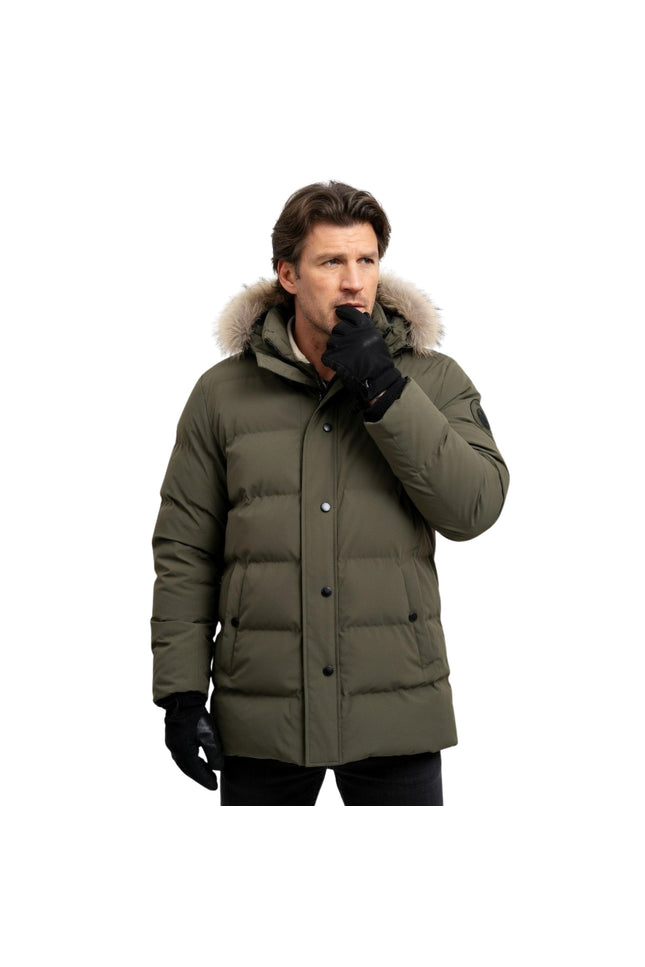 Man wearing a green winter coat with a fur-lined hood on a white background