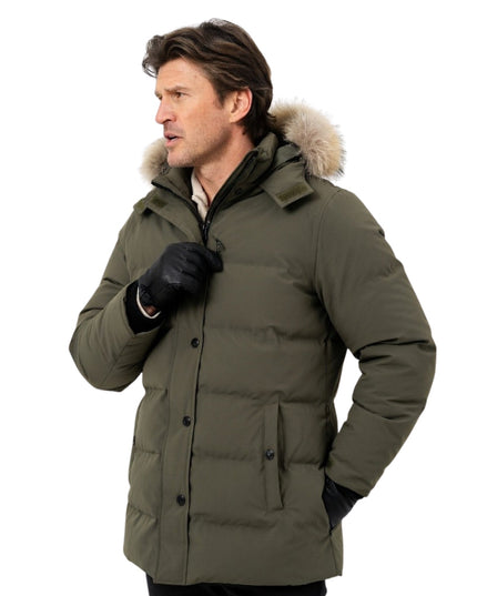 Man wearing a green winter coat with fur-lined hood on a white background