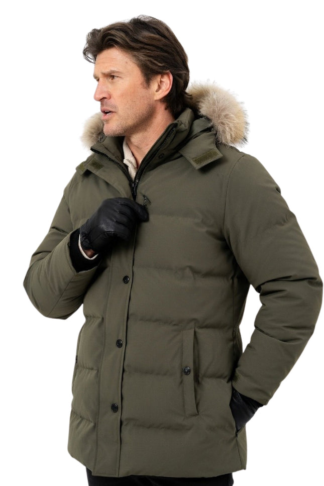 Man wearing a green winter coat with fur-lined hood on a white background