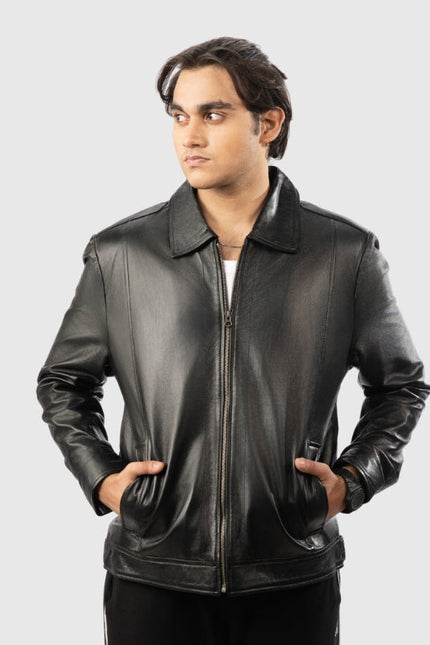 Man wearing a black leather jacket on a gray background