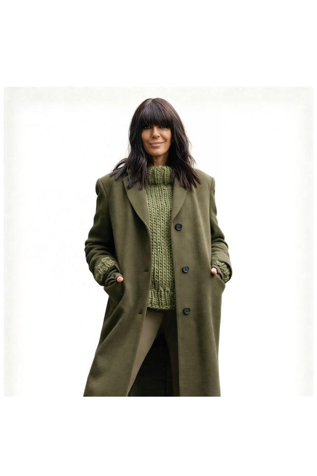 Woman wearing a green coat over a green knitted sweater on a white background