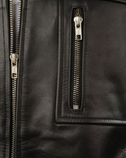 Close-up of a black leather jacket with gold zippers.