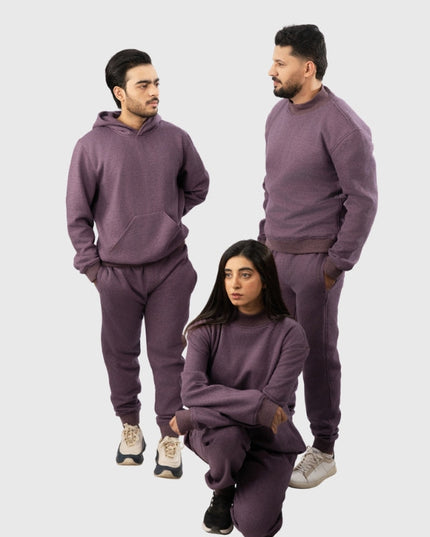 Three people wearing matching purple sweatsuits on a white background