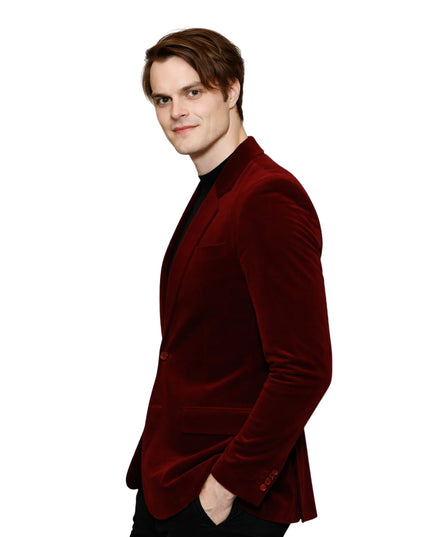 Man wearing a red velvet blazer on a white background