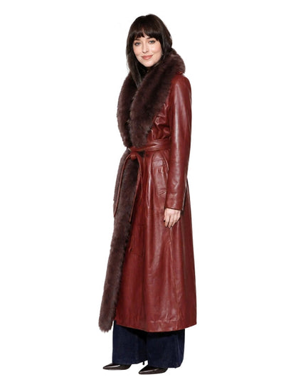 Woman wearing a long red leather coat with fur collar on a white background