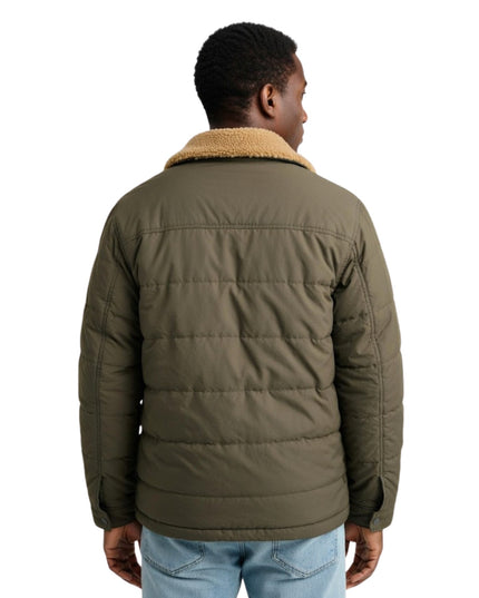 Person wearing a green puffer jacket with a white background