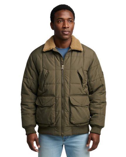 Man wearing a green quilted jacket with a beige fur collar on a white background