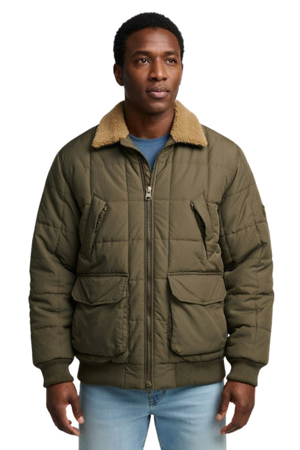 Man wearing a green quilted jacket with a beige fur collar on a white background