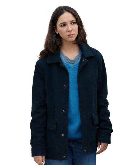 Woman wearing a dark blue coat over a blue sweater on a white background