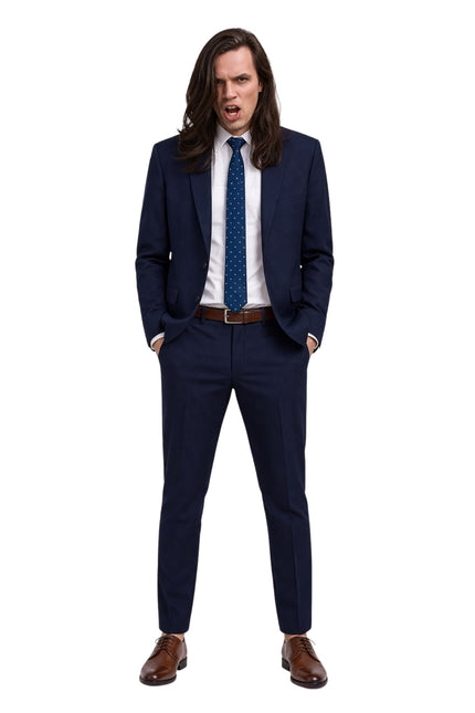 Man wearing a navy suit with a white shirt and brown shoes on a white background