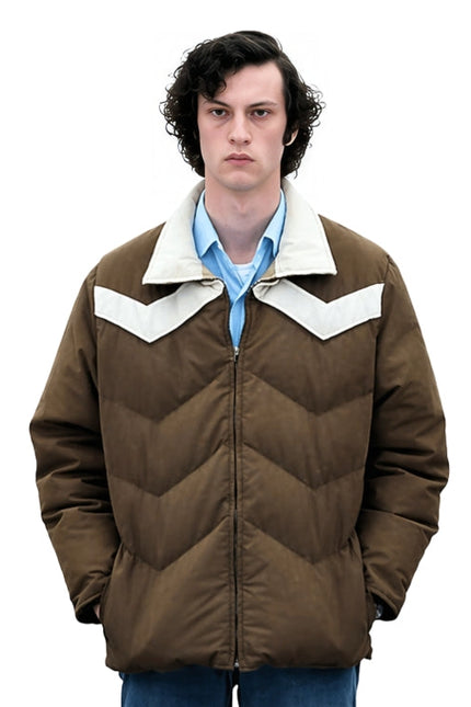 Person wearing a brown jacket with white collar and blue shirt on a white background