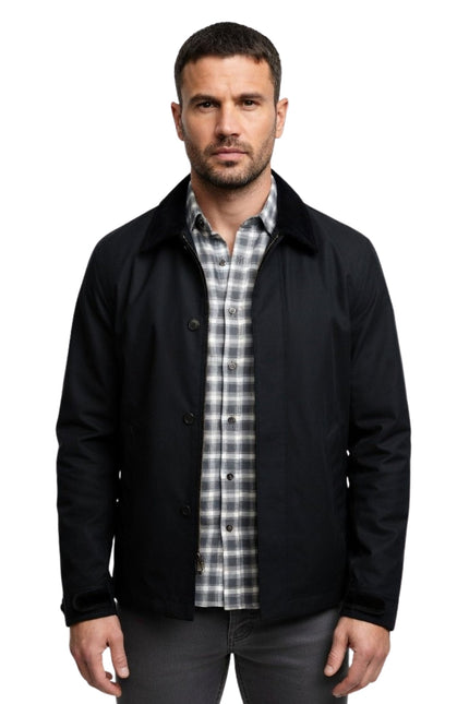 Man wearing a black jacket over a plaid shirt on a white background