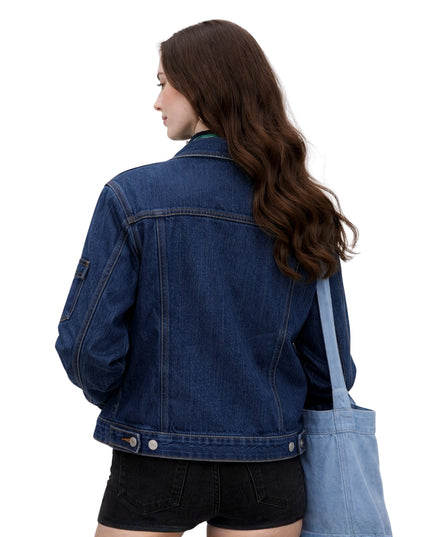 Person wearing a blue denim jacket and overalls on a white background