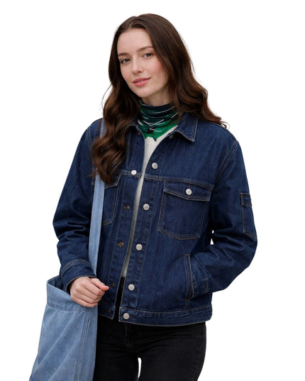 Woman wearing a blue denim jacket holding a blue tote bag on a white background
