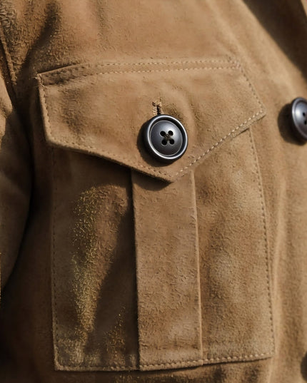 Close-up of a brown suede jacket with a button on a pocket